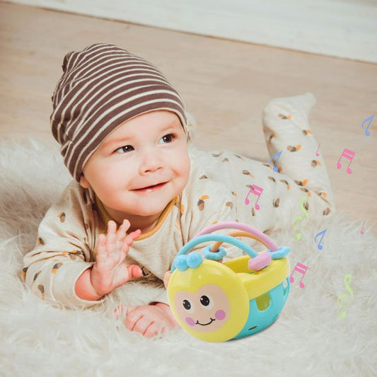 bebe alonger avec un hochet qui joue